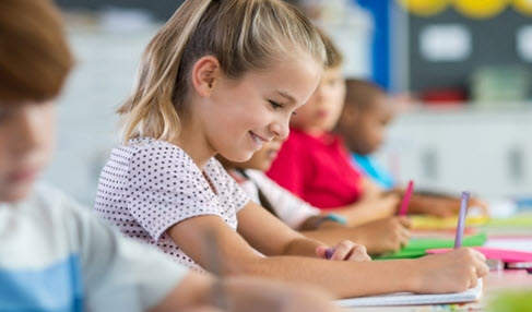 Mehrere Kinder sitzen an einem Schreibtisch und malen.