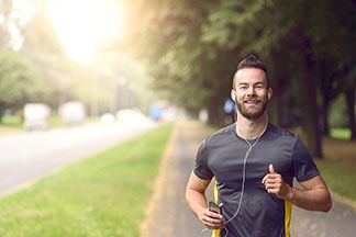 Ein Mann joggt mit seinem grauen Sportshirt.