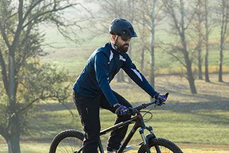 Ein Mann fährt Fahrrad mit seiner schwarzen Sportjacke.