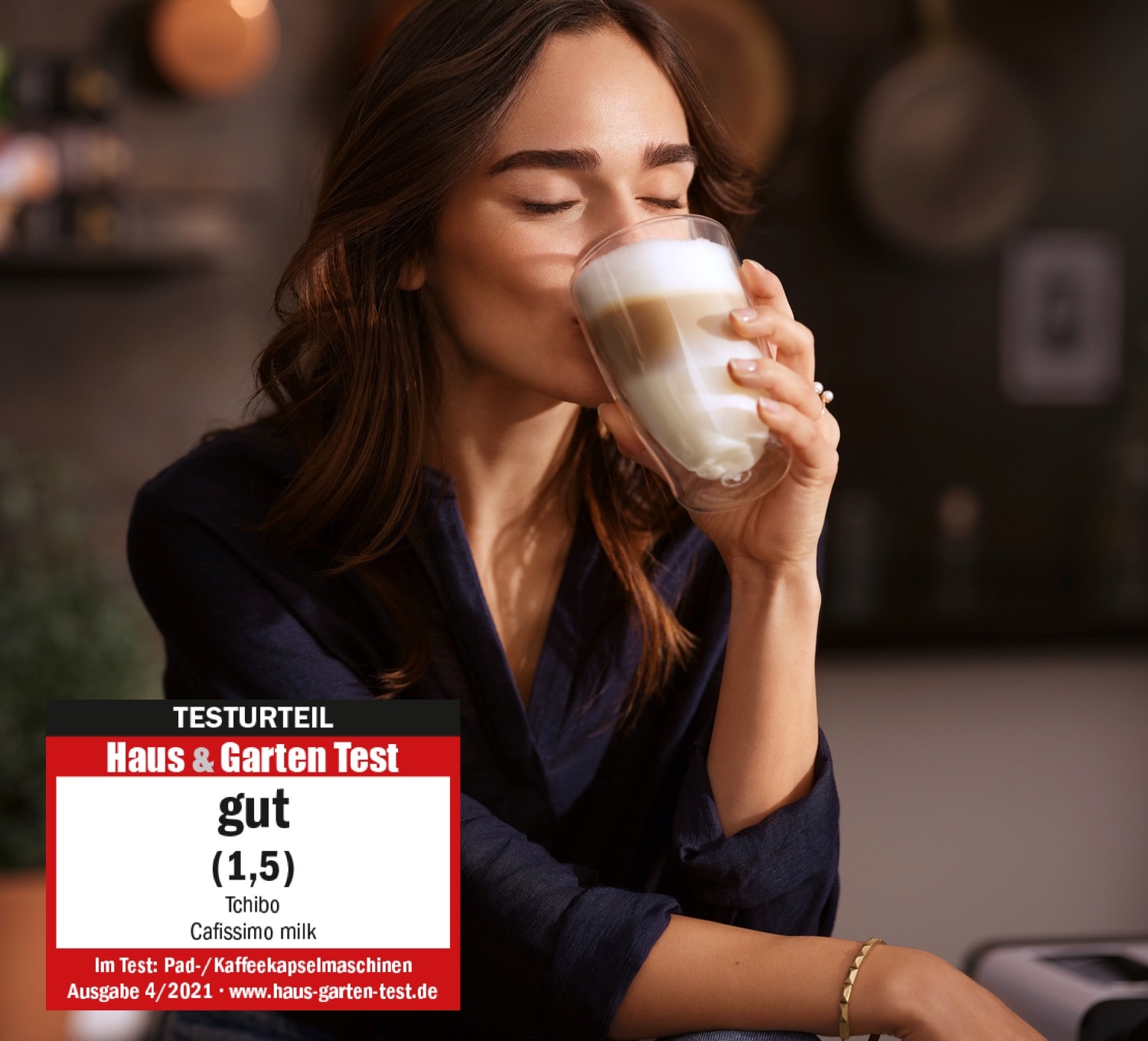 Eine Frau trinkt genüsslich einen Latte Macchiato