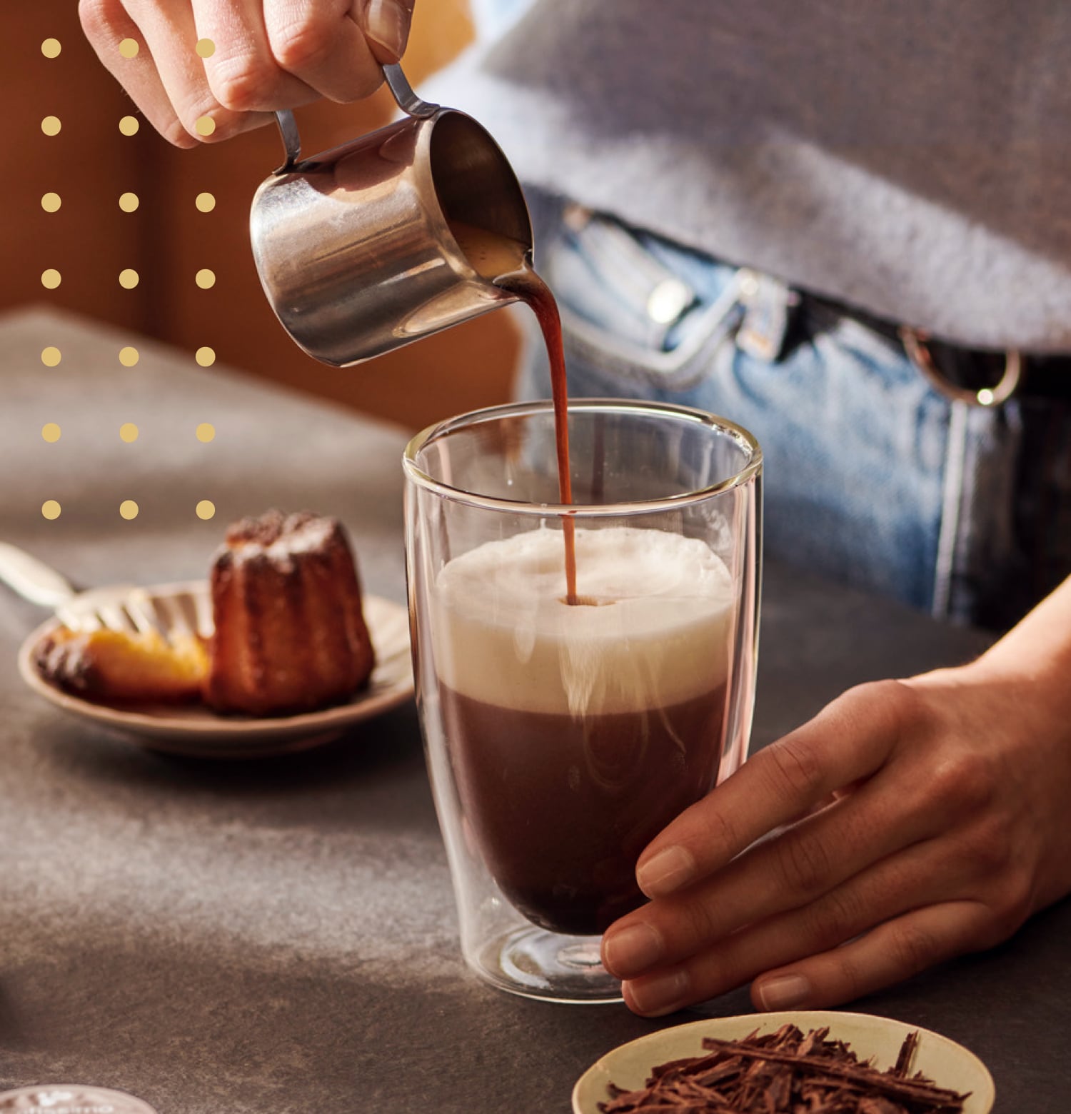 Eine Frau gießet einen Espresso in ein Latte Macchiato Glas, um einen Double Chocochiato zuzubereiten
