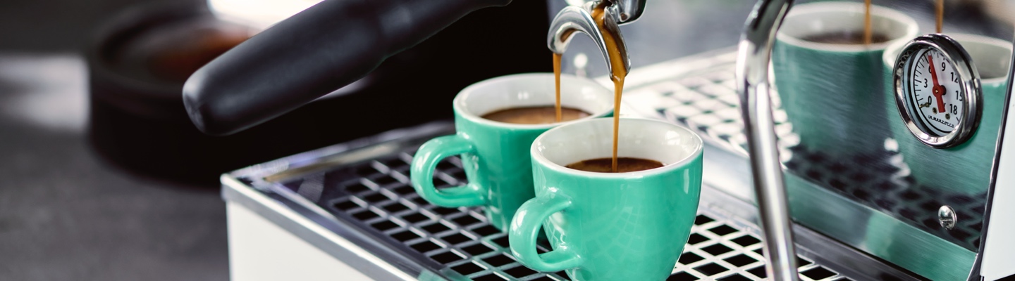 Espresso Tassen stehen unter einer Siebträgermaschine und es läuft ein Specialty Coffee Espresso in die Tasse.