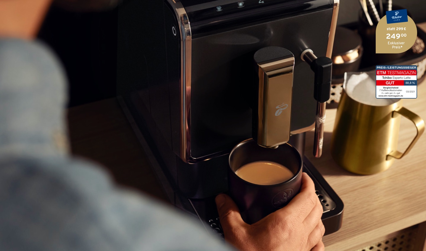 Der Esperto Latte auf einer Küchentheke mit einem frisch aufgebrühten Kaffee und einem goldenen Milchkännchen mit Milchschaum daneben