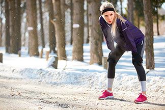 Eine Frau macht mit ihrer Outdoorhose eine Pause vom joggen.