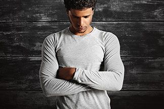Ein Mann trägt ein graues langarmiges Sportshirt.