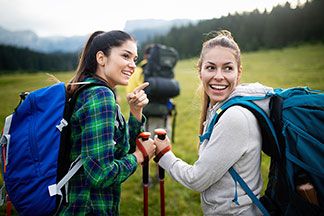 Zwei Frauen tragen verschiedene Sweatshirts beim Wandern.