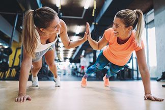Zwei Frauen machen in ihren Sportshirts Sport.