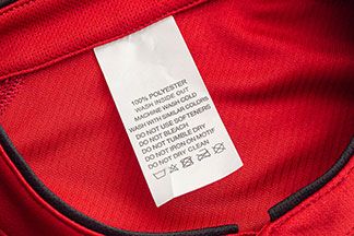 Eine Rote Sportjacke mit einem Etikett welches die Pflegehinweise beinhaltet.