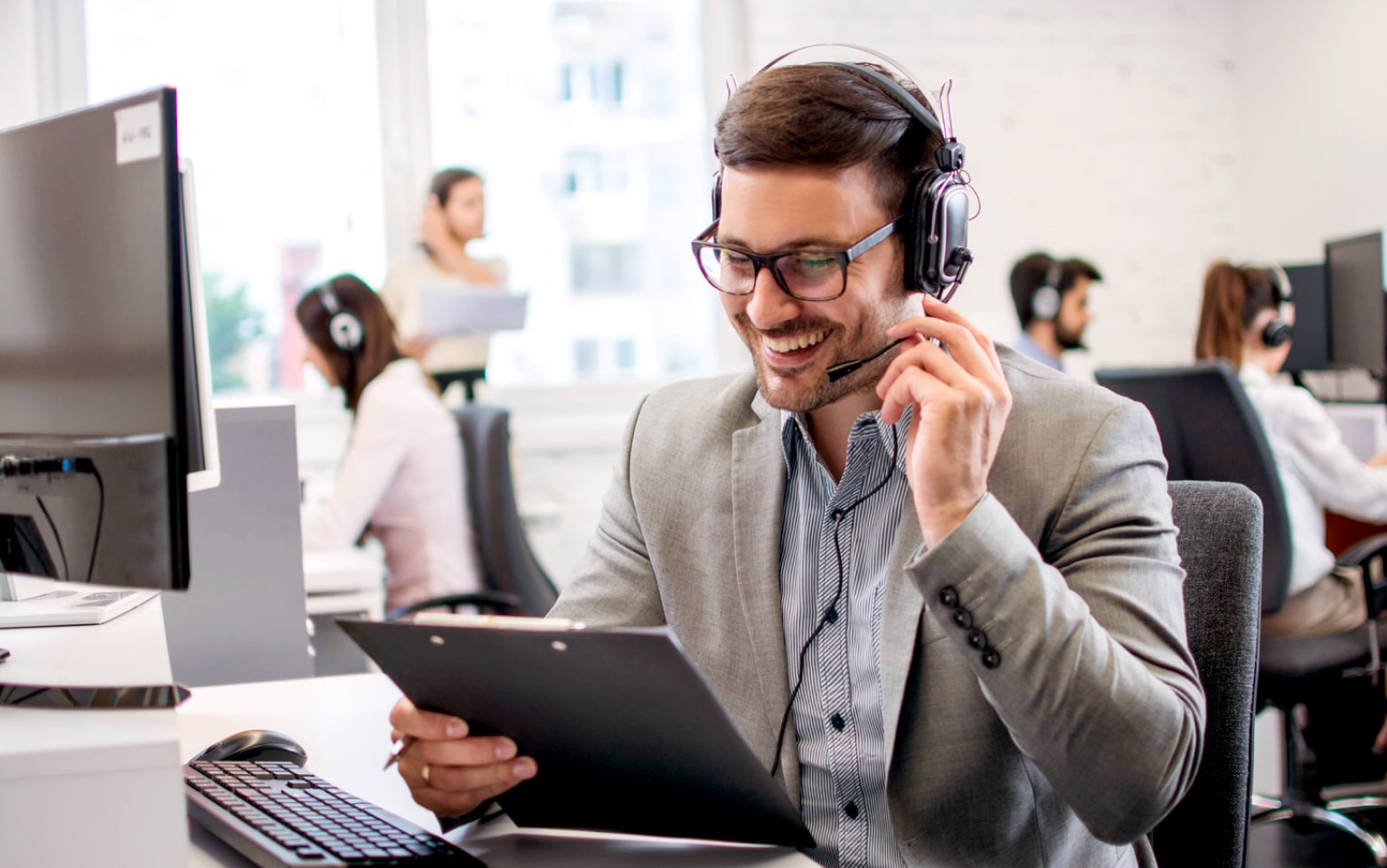 Ein Servicemitarbeiter sitzt am Telefon und beantwortet Fragen.
