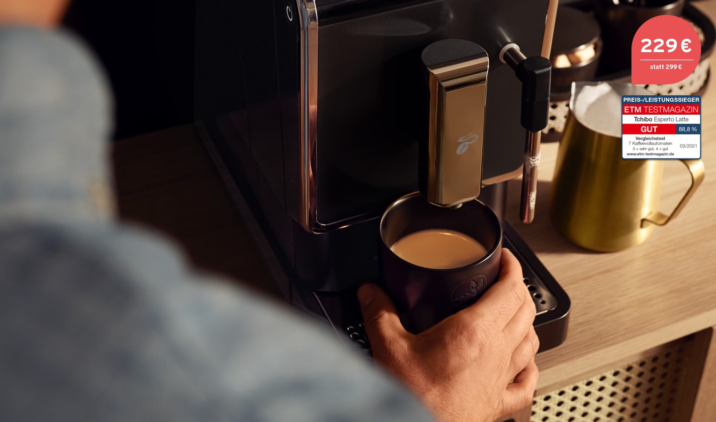 Der Esperto Latte auf einer Küchentheke mit einem frisch aufgebrühten Kaffee und einem goldenen Milchkännchen mit Milchschaum daneben