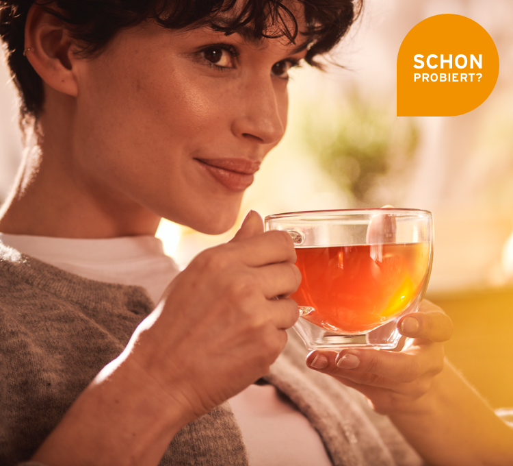 Eine Frau schlürft vorsichtig an ihrem Tee.