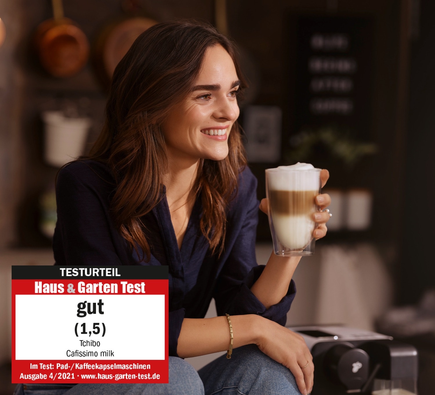 Eine Frau trinkt genüsslich einen Latte Macchiato
