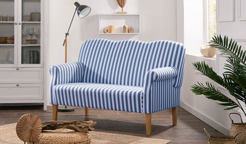 Auf dem weiß-blau-gestreiften Küchensofa, das neben einem Küchenschrank steht, sieht man nicht so viele Flecken.